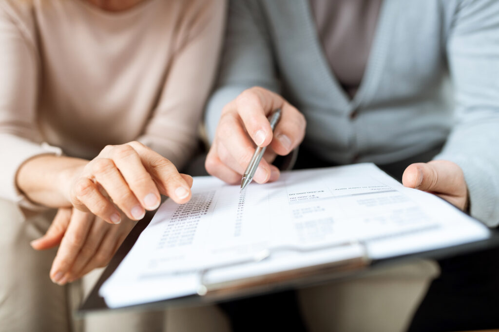 human hands pointing at one of points of contract or other document